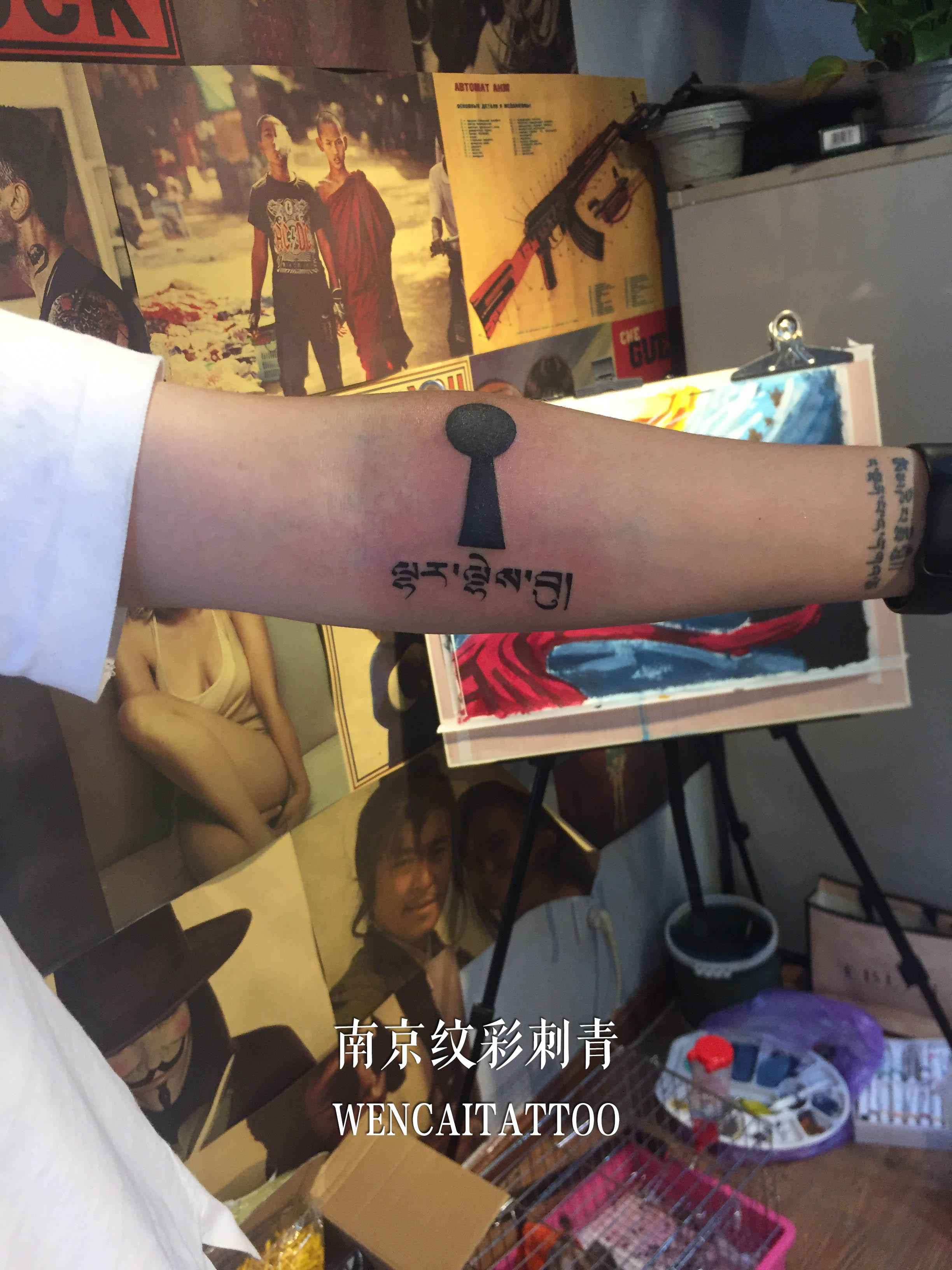 白衣帅哥李先生小臂上的钥匙空洞和梵文纹身图案