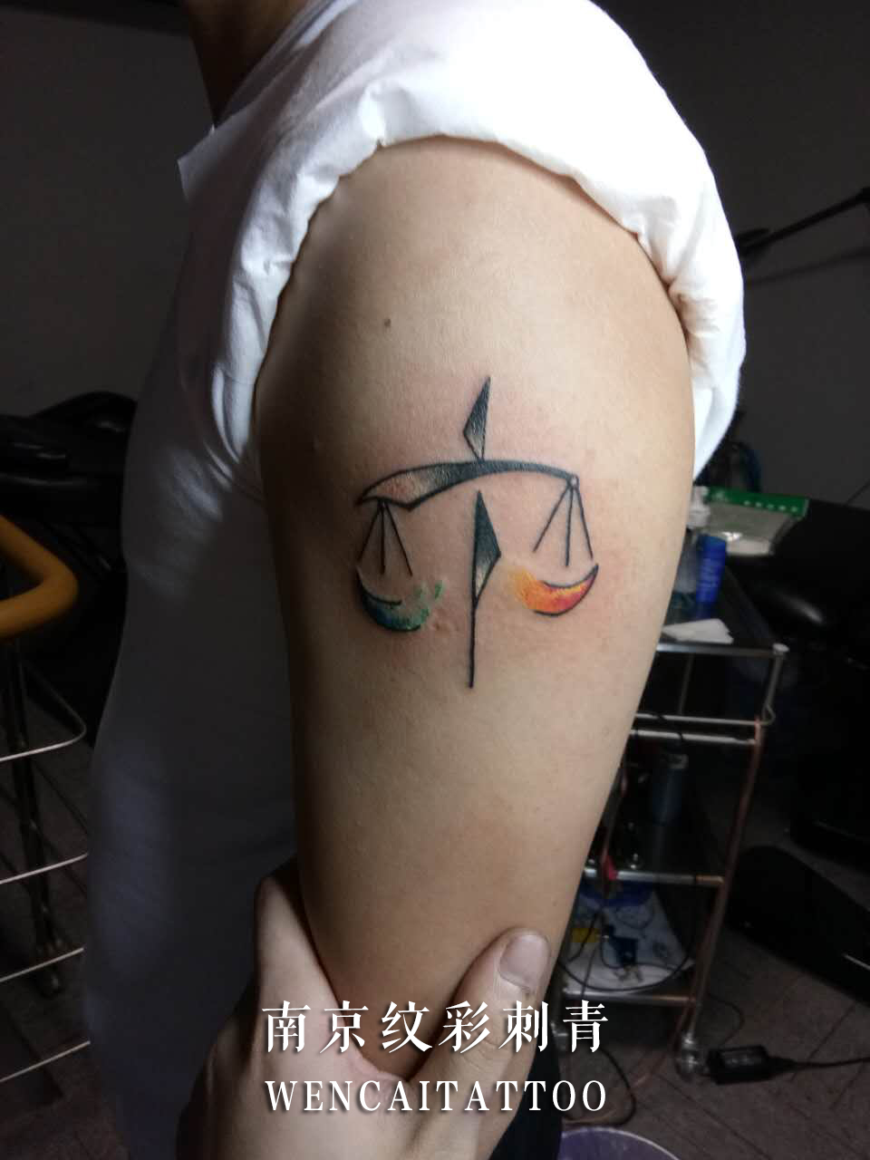 台先生大臂上的创意文字天平纹身图案